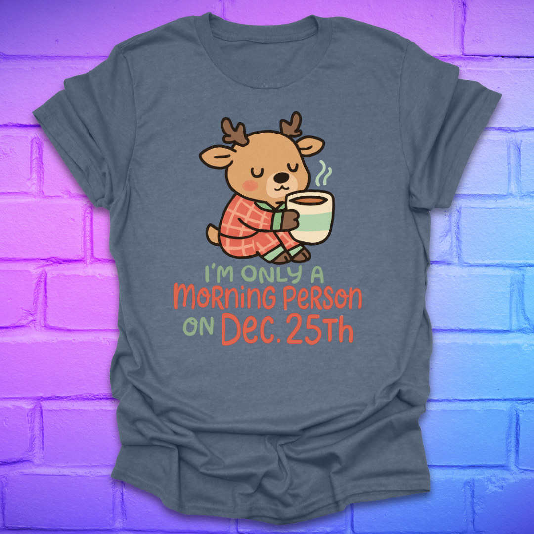 Indigo t-shirt with a cartoon deer holding a mug and text, 'only a morning person on Dec 25', on a brick wall background