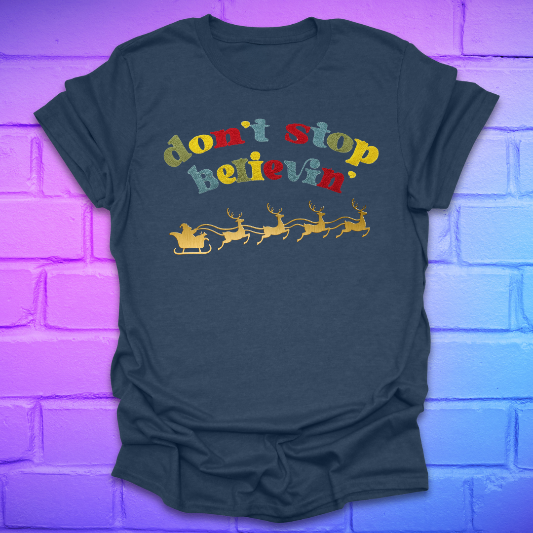 Heather navy blue tshirt with text, 'don't stop believin' with a santa and sleigh on a brick background