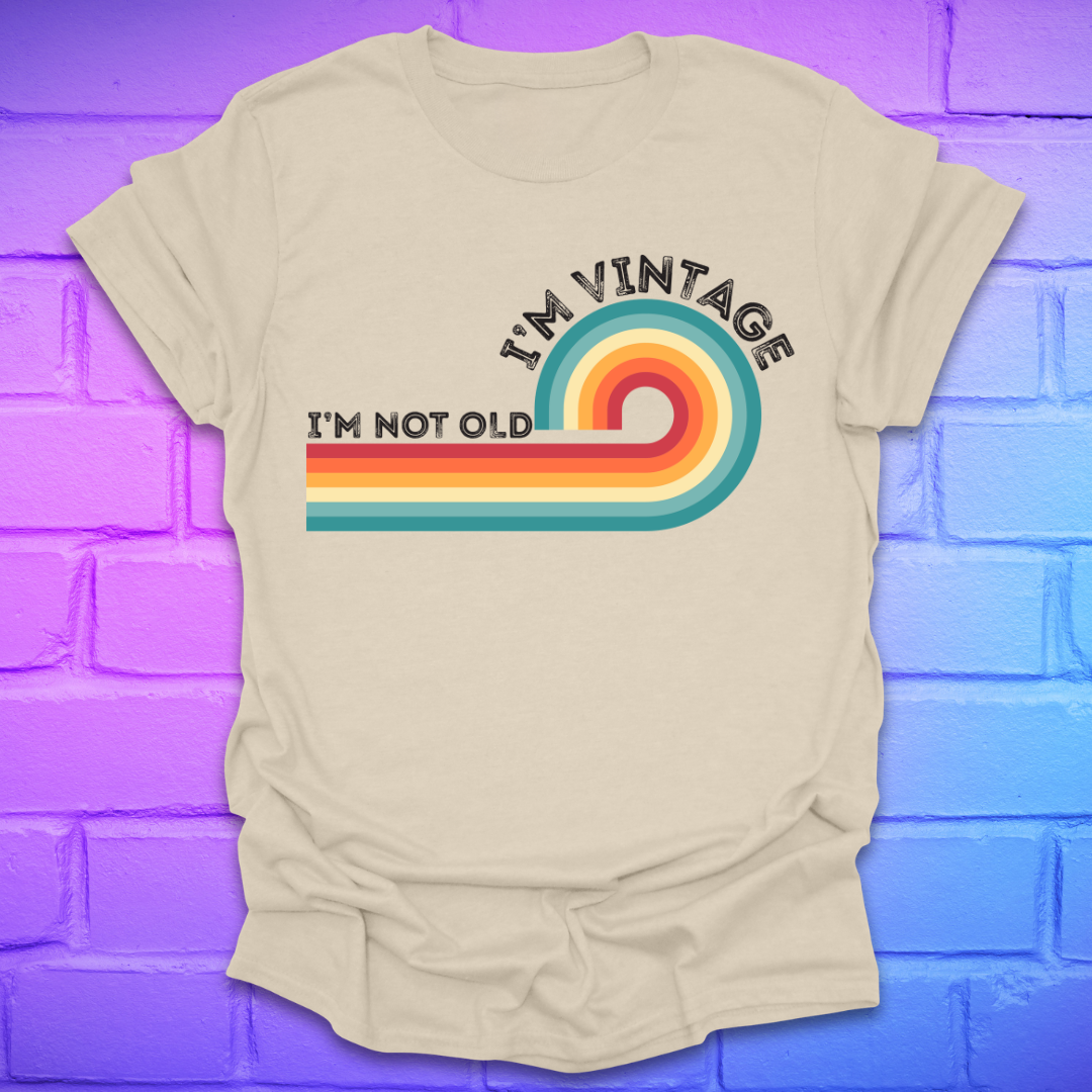 Beige t-shirt with colorful design and text on a blue and purple brick wall background