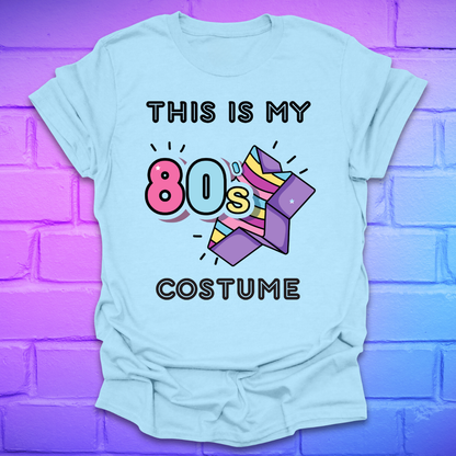 Light blue t-shirt with 'This is my 80s costume' text and graphics on a purple brick wall background