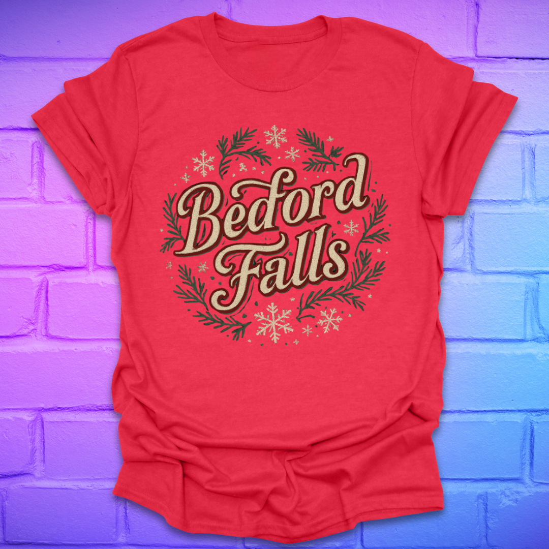Red T-shirt with chrismas theme text, "Bedford Falls" surrounded by pine and snowflakes on a brick background.