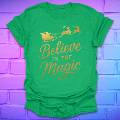 Green t-shirt with 'Believe in the Magic' text and Santa sleigh design on a purple brick wall background