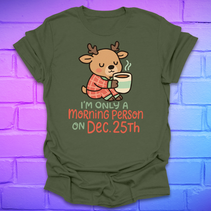 Green t-shirt with a cartoon deer holding a mug and text, 'only a morning person on Dec 25', on a brick wall background