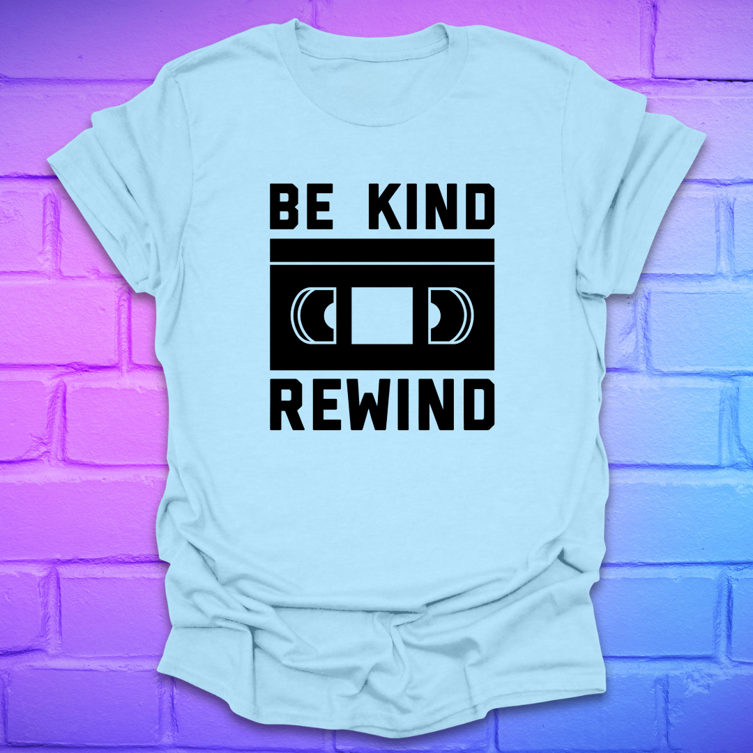 Light blue t-shirt with 'Be Kind Rewind' graphic on a purple brick wall background