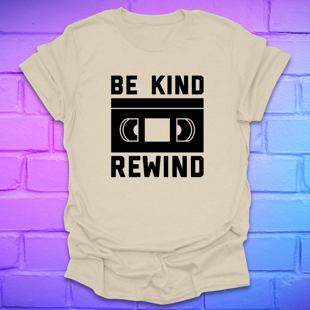 Beige t-shirt with 'Be Kind Rewind' graphic on a blue and purple brick wall background