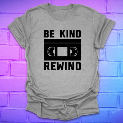 Gray t-shirt with 'Be Kind Rewind' text design on a brick wall background