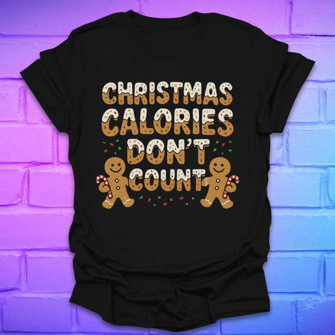 Black tshirt with festive gingerbread text, 'Christmas calories don't count' with gingerbread men on a brick background.