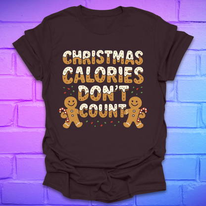 Brown tshirt with festive gingerbread text, 'Christmas calories don't count' with gingerbread men on a brick background.