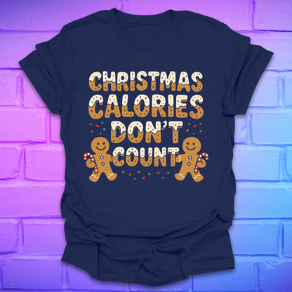 Navy tshirt with festive gingerbread text, 'Christmas calories don't count' with gingerbread men on a brick background.