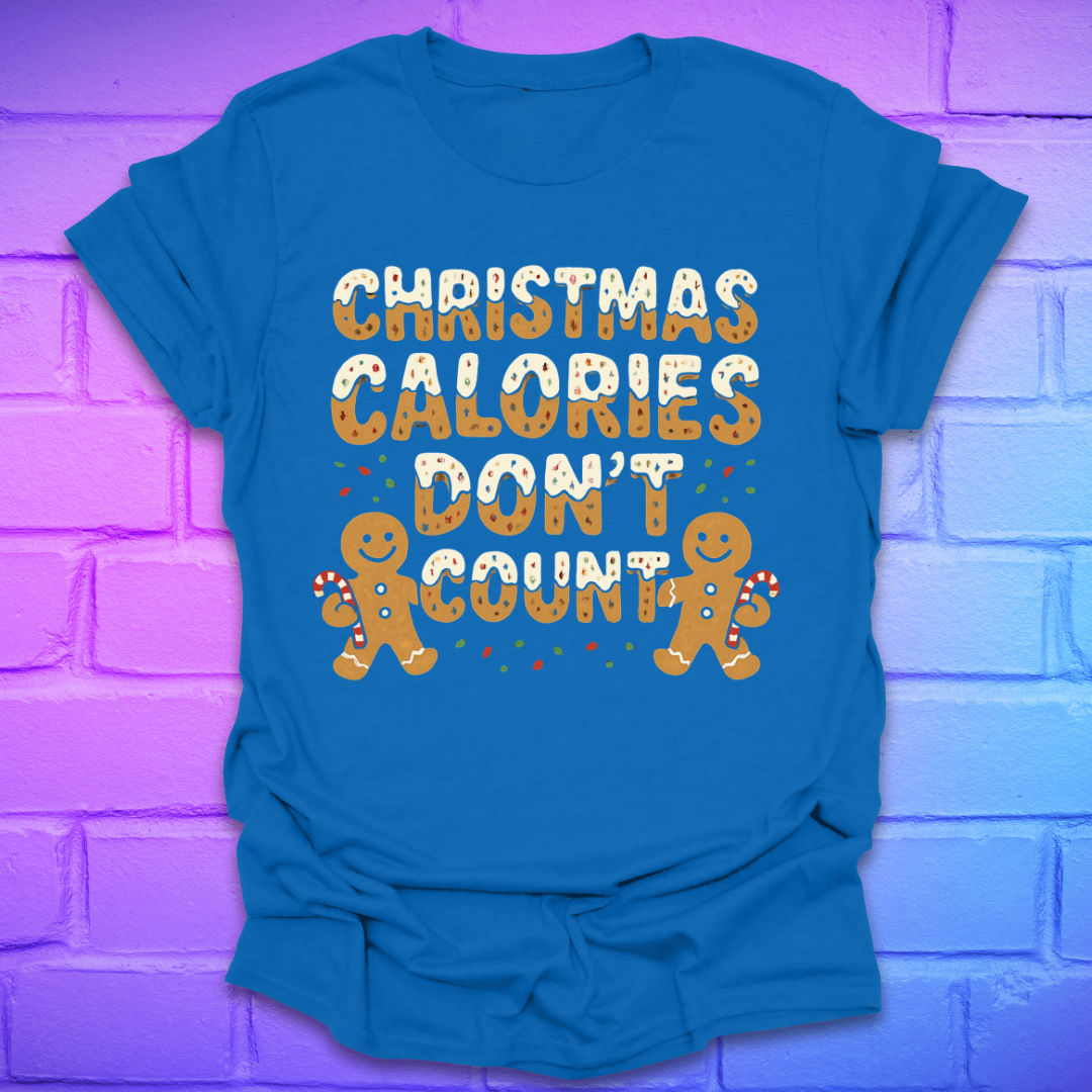 Royal blue tshirt with festive gingerbread text, 'Christmas calories don't count' with gingerbread men on a brick background.