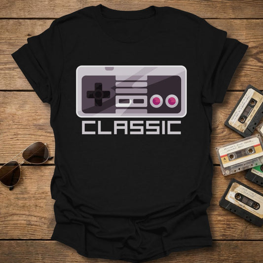 Black t-shirt with a gaming controller graphic and 'CLASSIC' text on a wooden surface with vintage items.