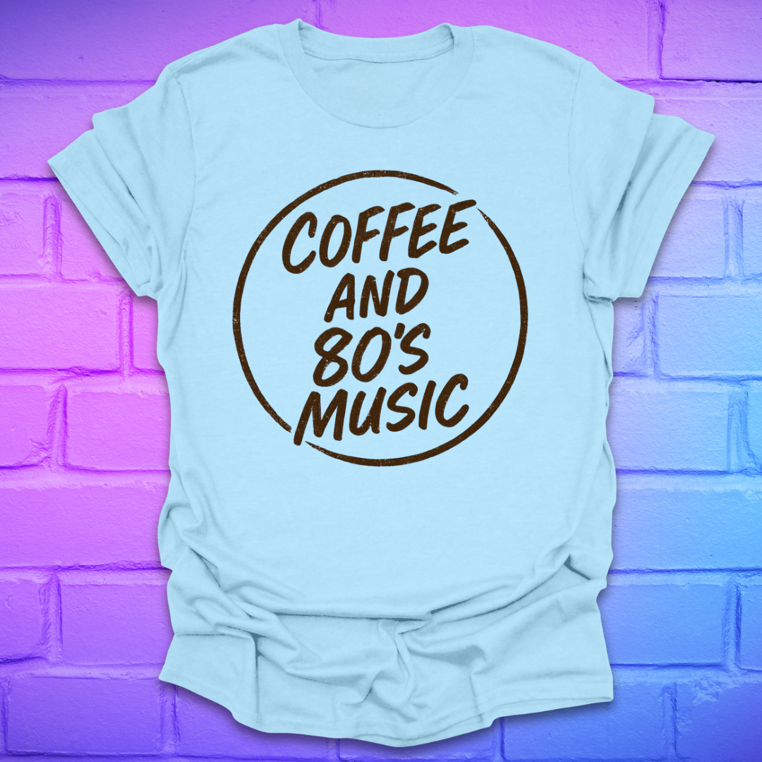 Light blue t-shirt with 'Coffee and 80's Music' text on a purple brick wall background