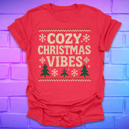 Red t-shirt with 'Cozy Christmas Vibes' text and festive graphics on a colorful brick wall background