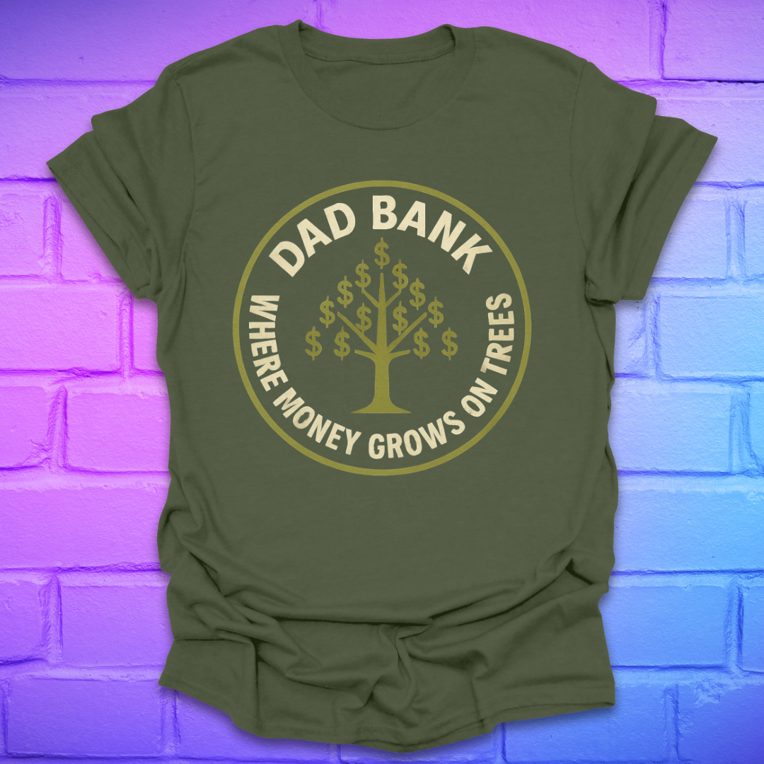 Green t-shirt with gold graphic and text 'Dad Bank. where money grows on trees' on a brick wall background