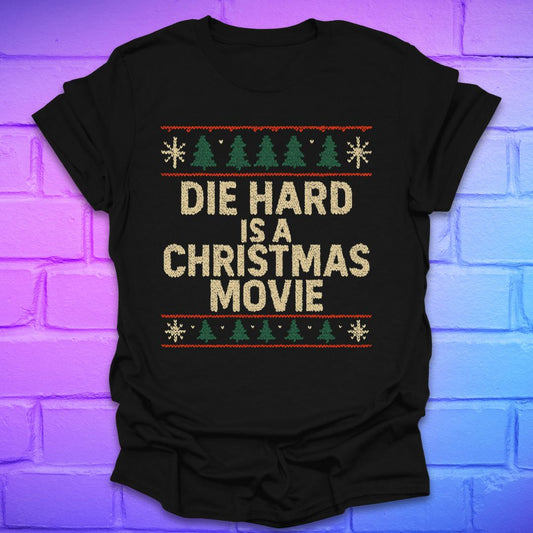Black t-shirt with sweater print 'Die Hard is a Christmas Movie' text on a brick wall background