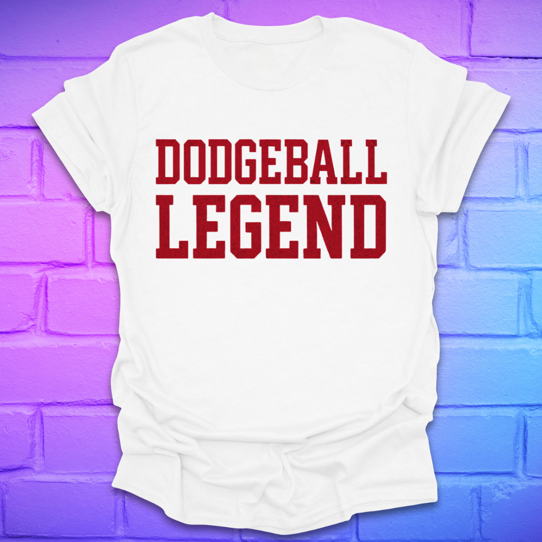White t-shirt with 'Dodgeball Legend' text on a purple brick wall background