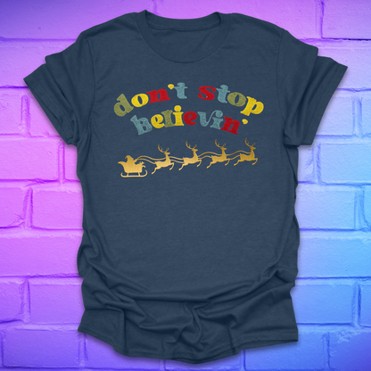 Heather navy blue tshirt with text, 'don't stop believin' with a santa and sleigh on a brick background