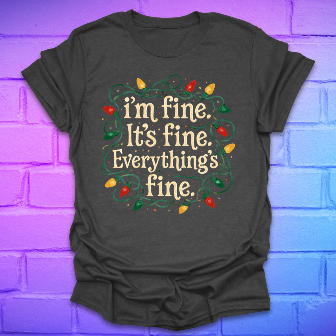 Dark grey t-shirt with tangled christmas lights and text 'I'm fine. it's fine. everything's fine.' on a brick background.