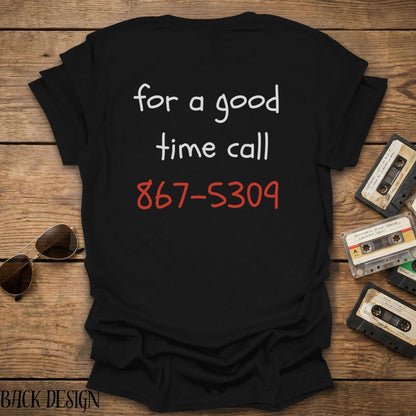 Black t-shirt with text 'for a good time call 867-5309' on a wooden surface with vintage cassettes and sunglasses.