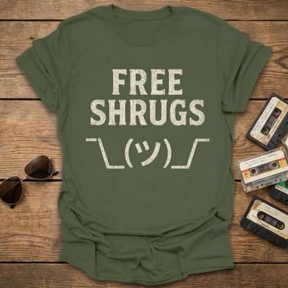 Green t-shirt with 'FREE SHRUGS' text on a wooden surface with sunglasses and cassettes.