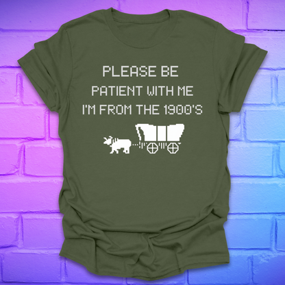 Green t-shirt with white text, 'please be patient with me im from the 1900s' and graphics on a brick wall background