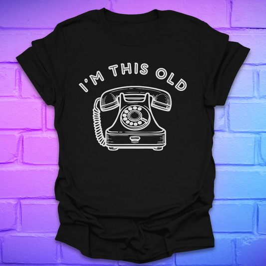 Black t-shirt with a vintage telephone graphic and text 'I'm this old' on a brick wall background.