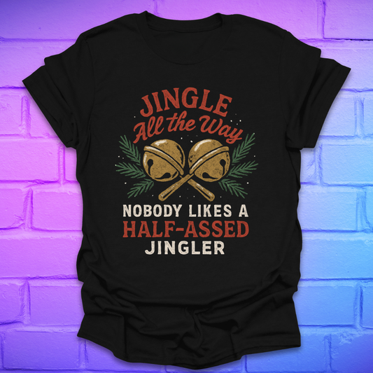 Black t-shirt with Christmas-themed text and jingle bells graphic on a brick wall background