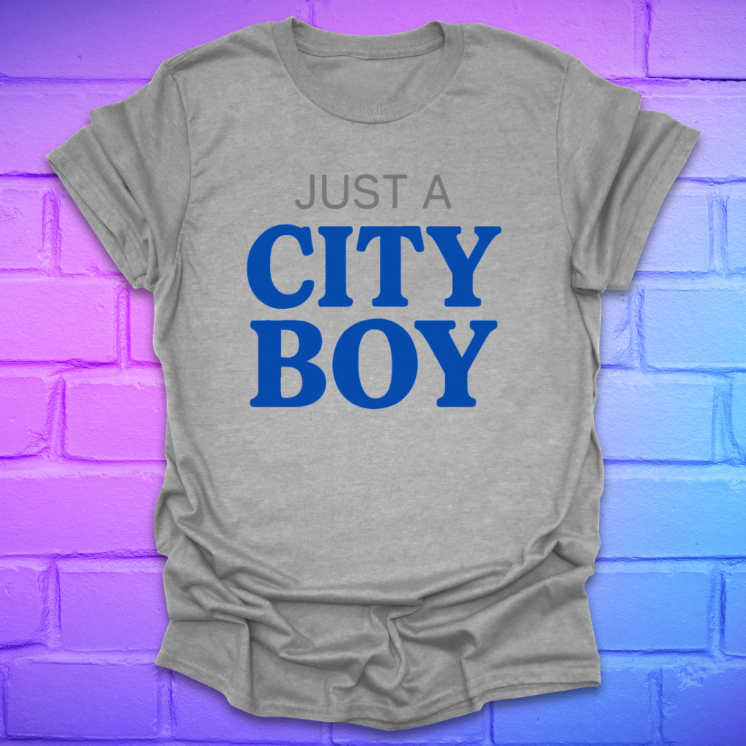 Gray t-shirt with 'Just a City Boy' text in blue on a brick wall background