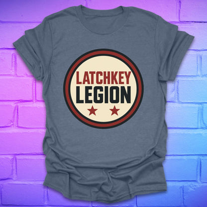 Indigo colored t-shirt with text, 'Latchkey Legion'  in a circle with stars design on a brick wall background