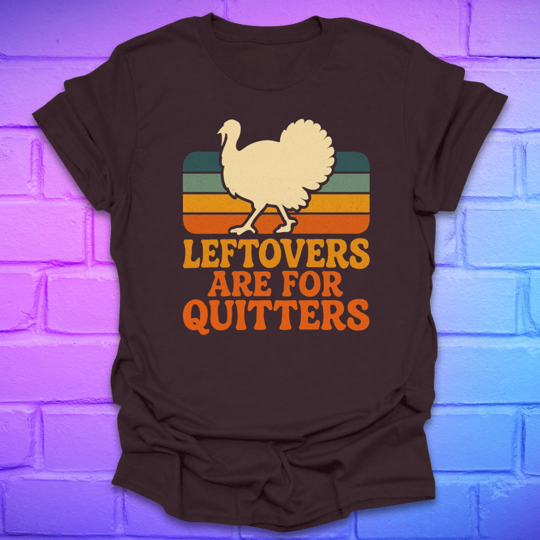 Brown t-shirt with a graphic of a turkey and text 'LEFTOVERS ARE FOR QUITTERS' on a brick wall background.