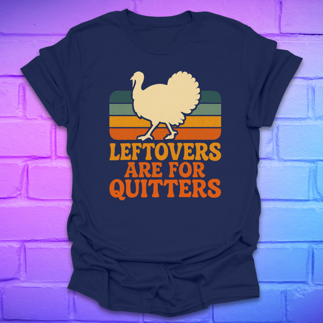 Navy blue t-shirt with a graphic of a turkey and text 'LEFTOVERS ARE FOR QUITTERS' on a brick wall background.