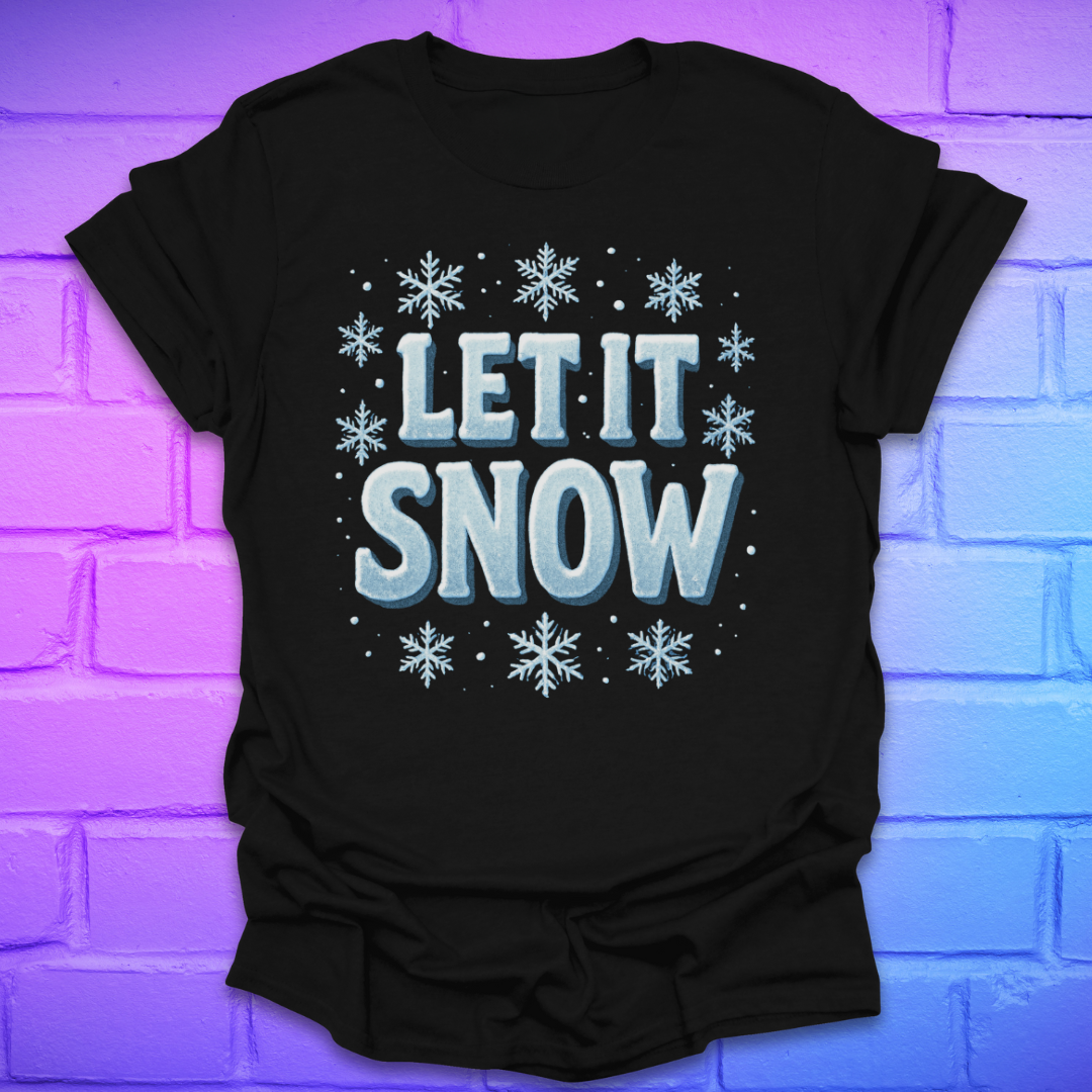 Black t-shirt with 'LET IT SNOW' text and snowflakes on a brick wall background