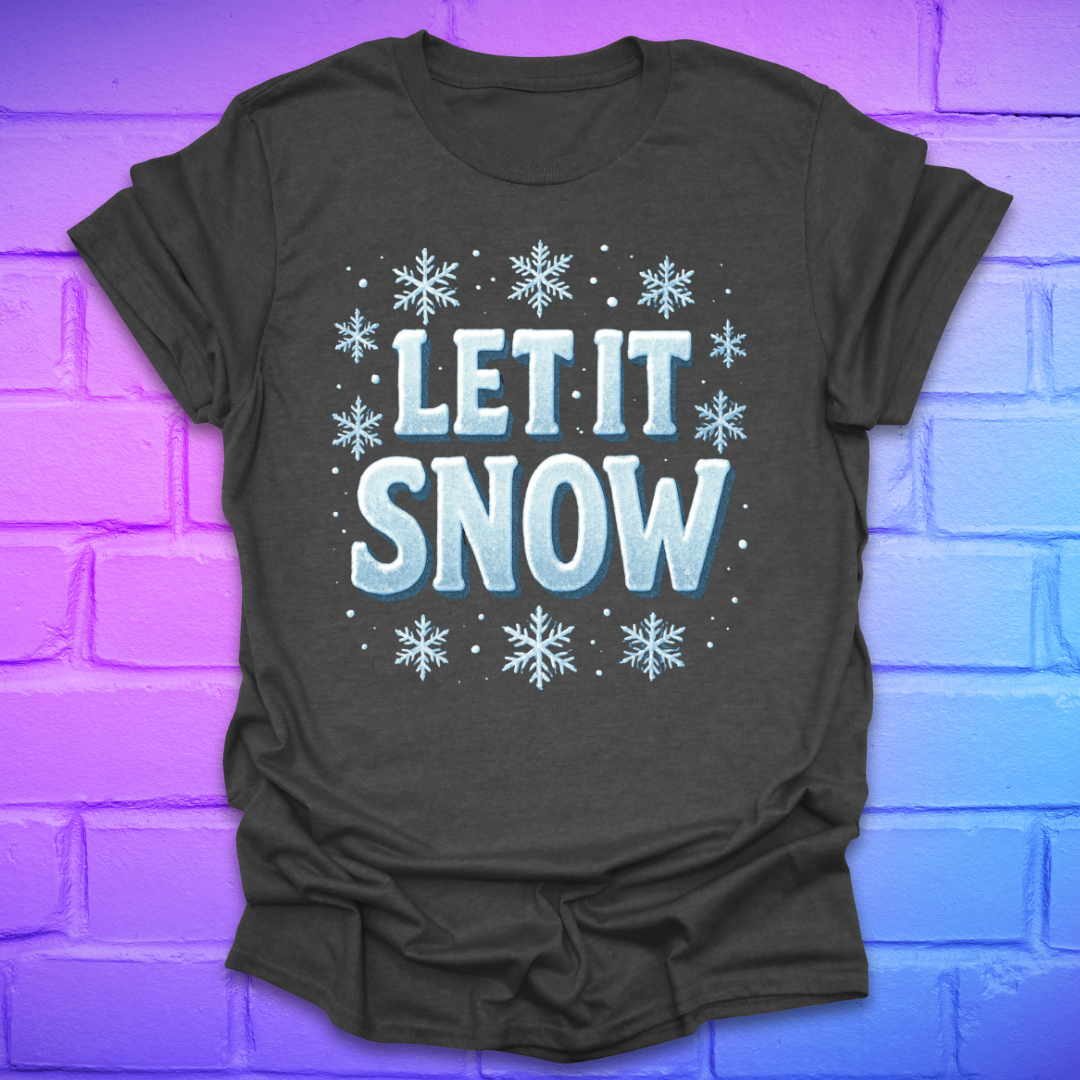 Dark gray t-shirt with 'LET IT SNOW' text and snowflakes on a brick wall background