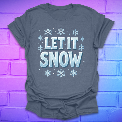 Indigo t-shirt with 'LET IT SNOW' text and snowflakes on a purple brick wall background