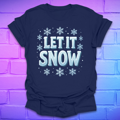 Navy blue t-shirt with 'LET IT SNOW' text and snowflakes on a brick wall background