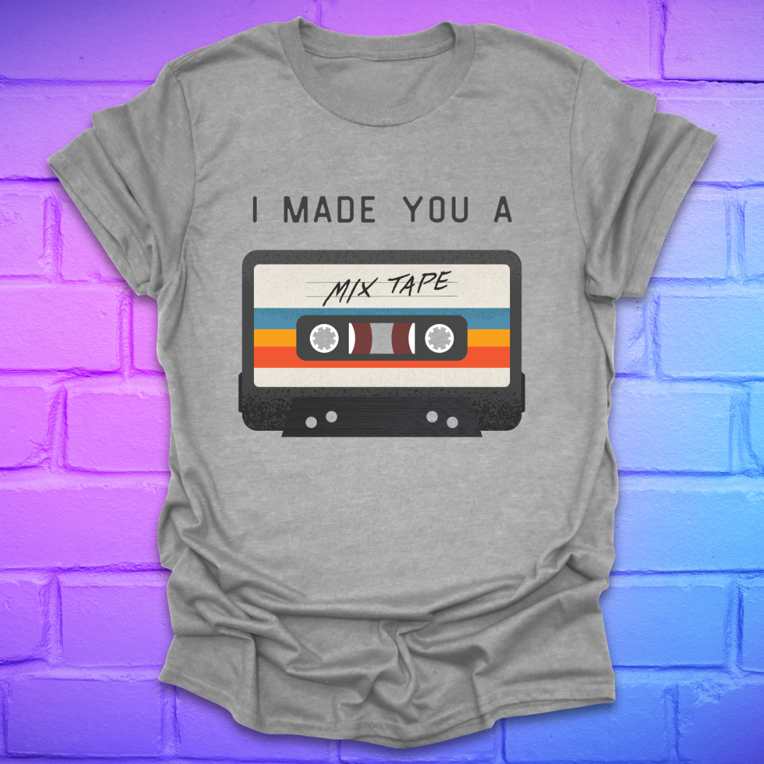 Grey tshirt with the text 'I made you a mix tape' with a graphic of a cassette tape on a brick background. 