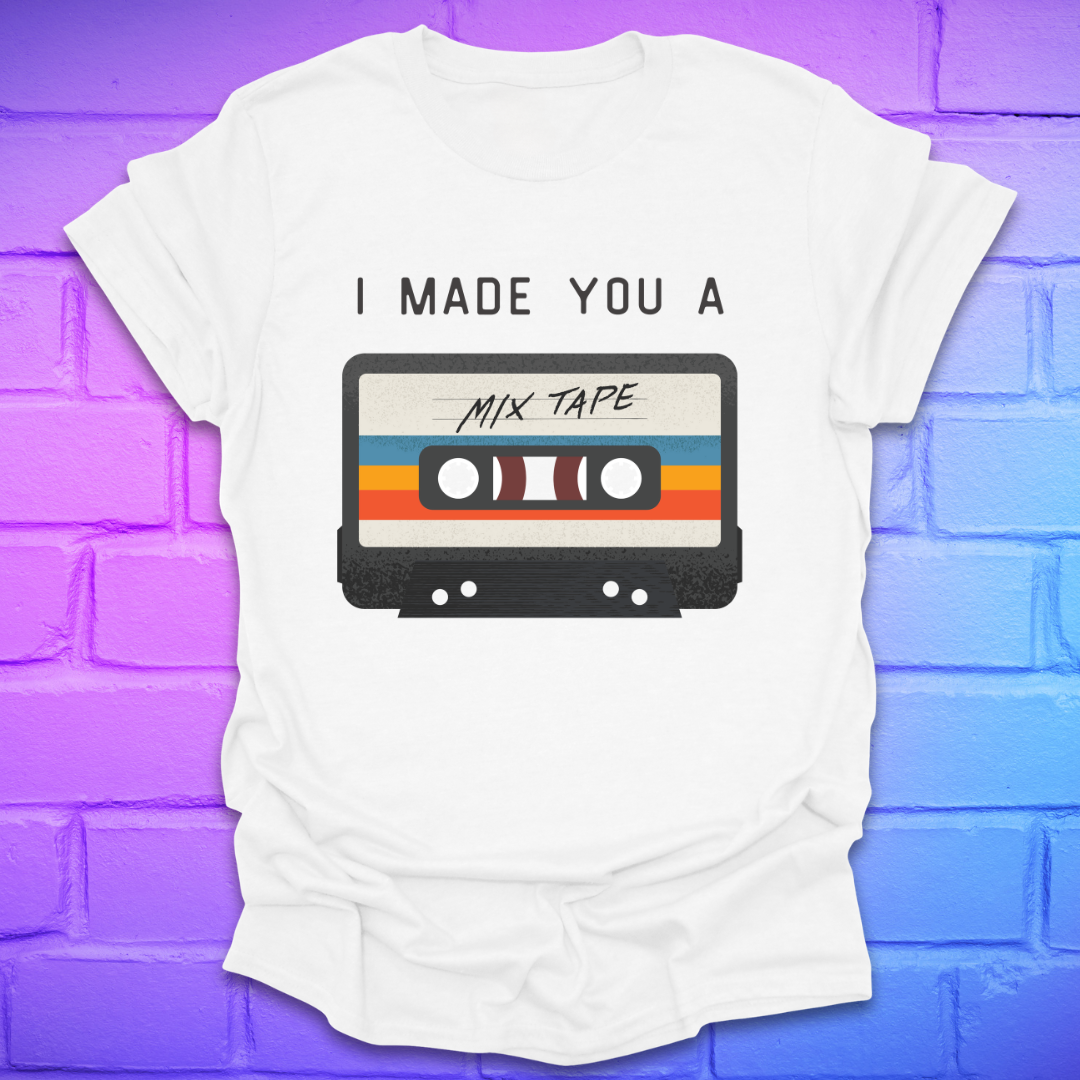 White tshirt with the text 'I made you a mix tape' with a graphic of a cassette tape on a brick background. 