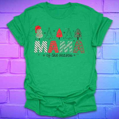 Green t-shirt with 'Mama of the season' text and Christmas tree graphics on a purple brick wall background.