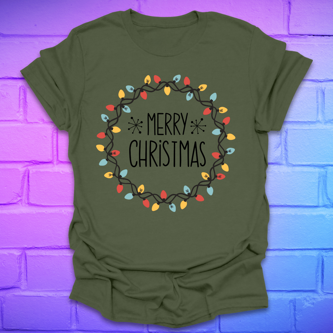 Green t-shirt with 'Merry Christmas' design with christmas lights on a brick wall background
