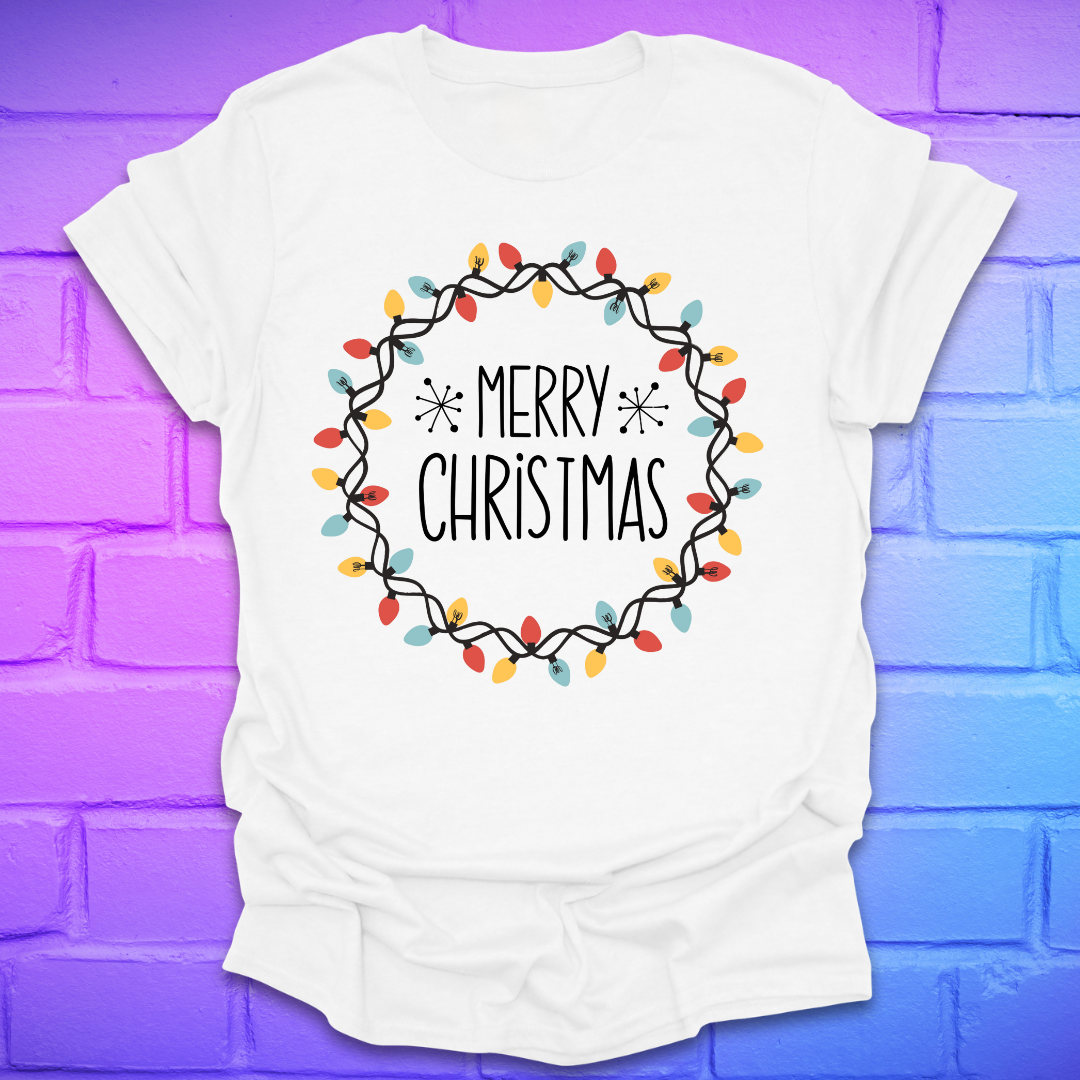 White t-shirt with 'Merry Christmas' design with christmas lights on a brick wall background
