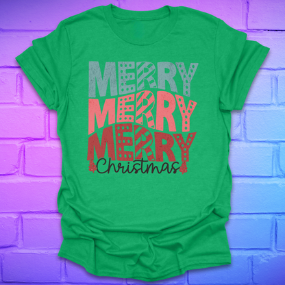 Green t-shirt with 'Merry Christmas' text on a purple brick wall background