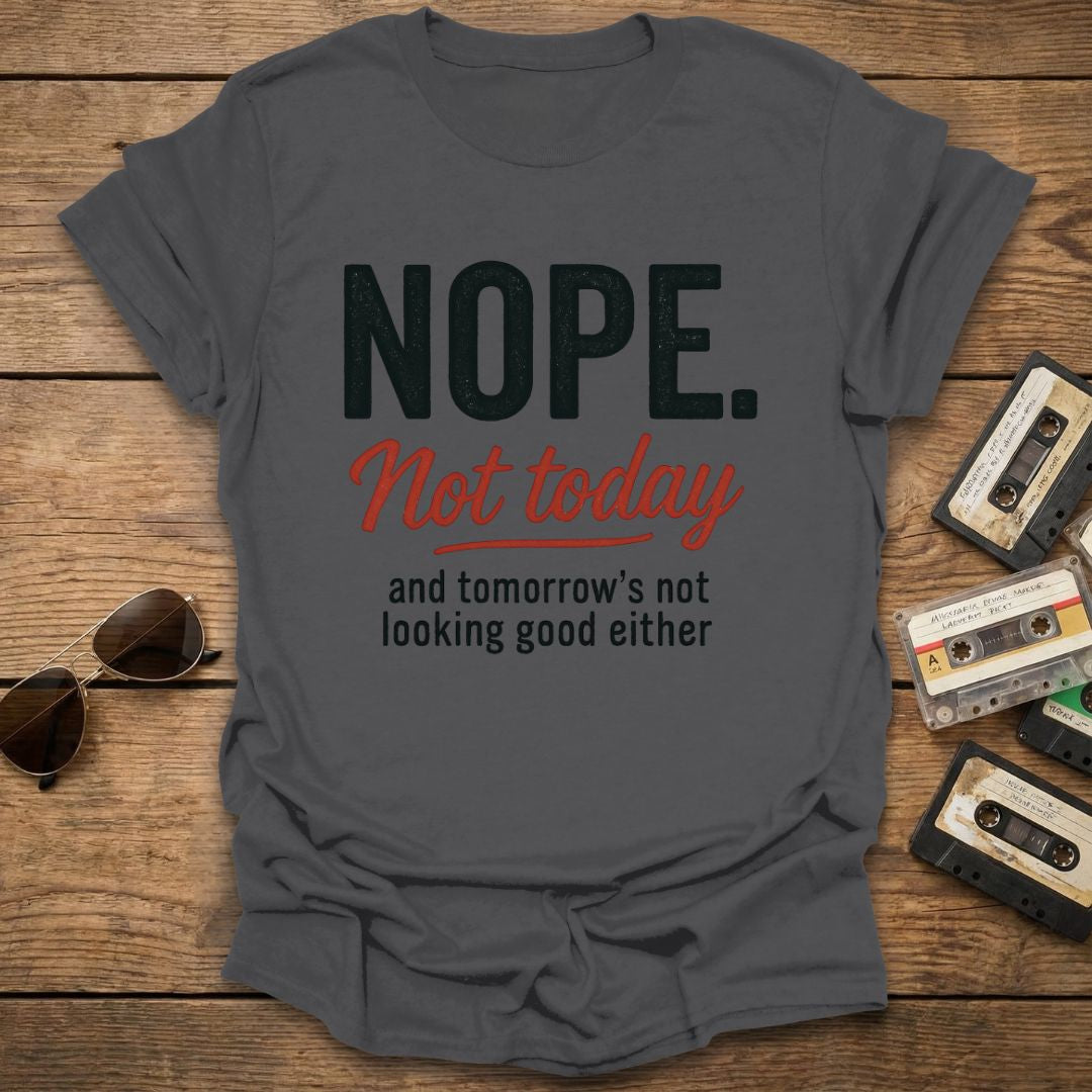 Gray t-shirt with 'NOPE. Not today and tomorrow's not looking good either' text on a wooden surface with sunglasses and cassettes.