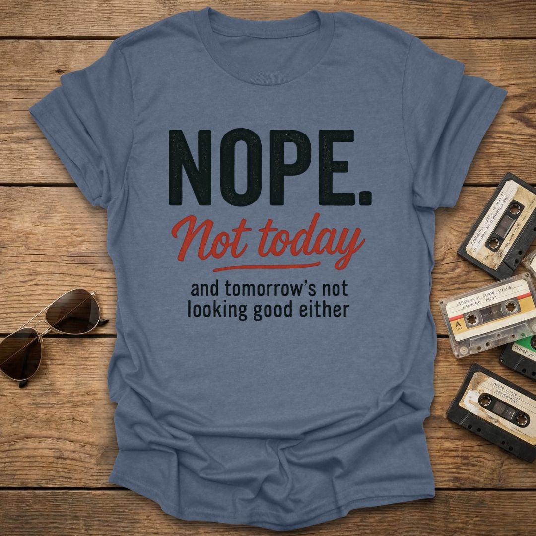 Blue t-shirt with 'NOPE. Not today and tomorrow's not looking good either' text on a wooden surface with sunglasses and cassettes.