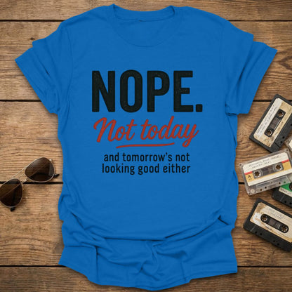 Royal blue t-shirt with text 'NOPE. Not today and tomorrow's not looking good either' on a wooden surface with sunglasses and cassettes.
