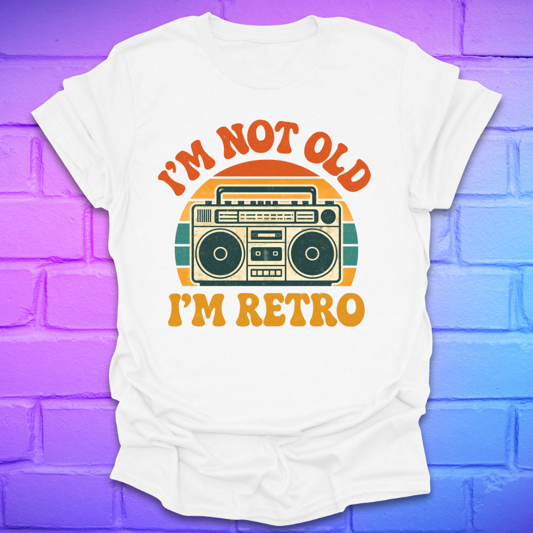 White t-shirt with a graphic and text 'I'm not old, I'm retro' on a colorful brick wall background
