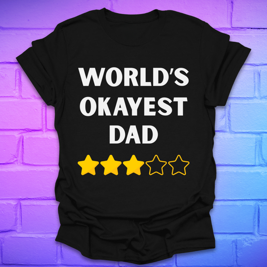 Black t-shirt with 'World's Okayest Dad' text and star ratings on a brick wall background