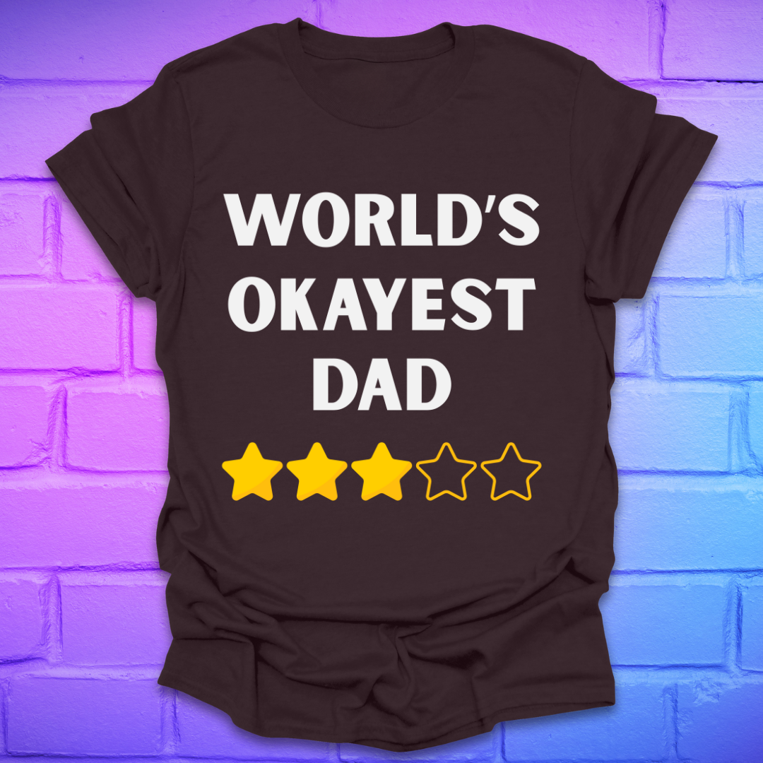 Brown t-shirt with 'World's Okayest Dad' text and star ratings on a brick wall background