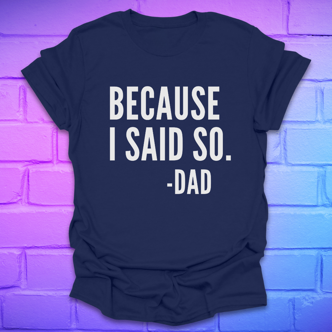 Navy blue t-shirt with 'BECAUSE I SAID SO. -DAD' text on a brick wall background