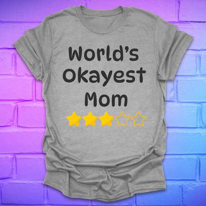Gray t-shirt with 'World's Okayest Mom' text and star ratings on a purple brick wall background