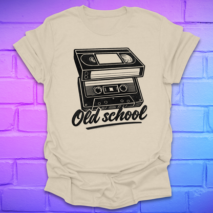 Beige t-shirt with a cassette tape graphic and 'Old school' text on a blue and purple brick wall background.